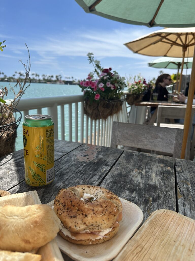 Fresh smoked salmon bagel and coffee on a wooden table at a waterfront cafe in Honolulu Hawaii