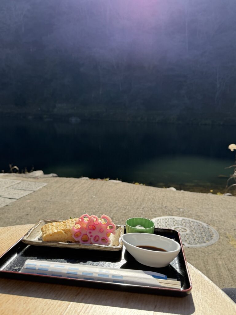 Fluffy Japanese rolled omelet (Tamagoyaki) with a scenic riverside view of Arashiyama in the background.