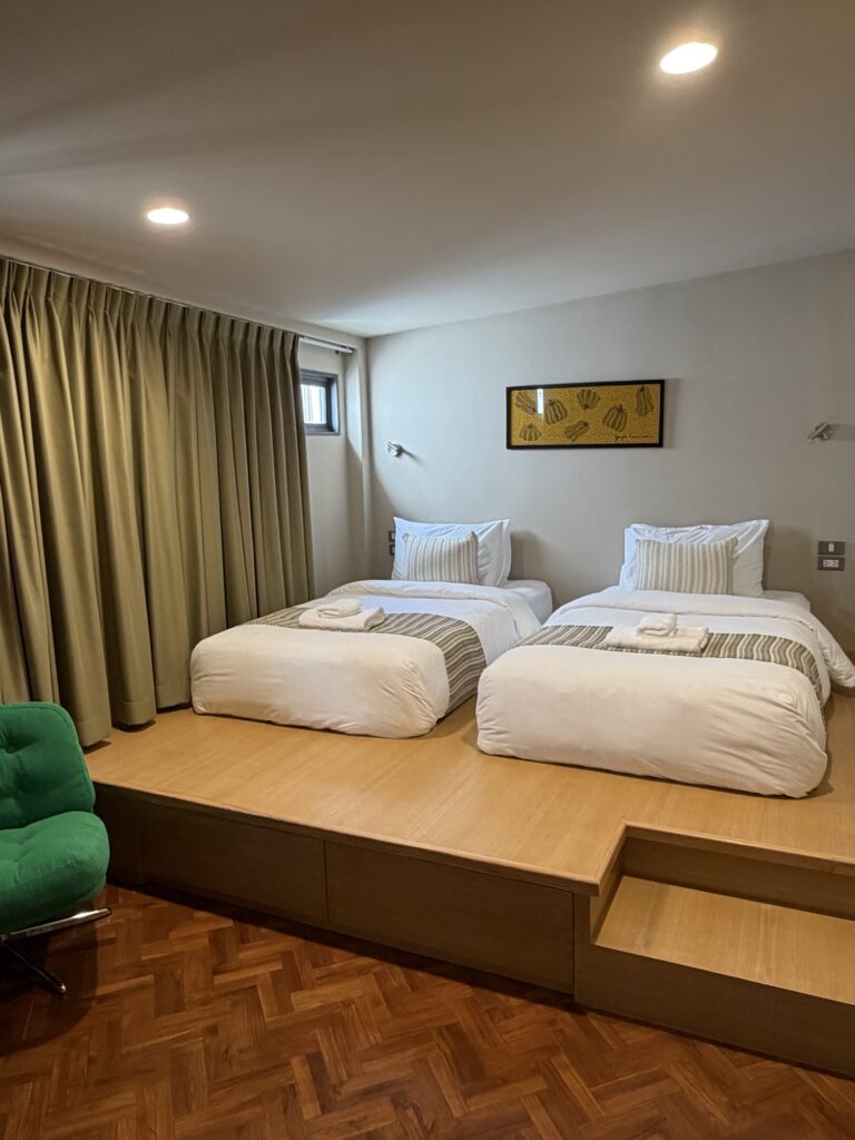 Comfortable bedroom with clean white bedding at Introvert Haus Chiang Mai.
